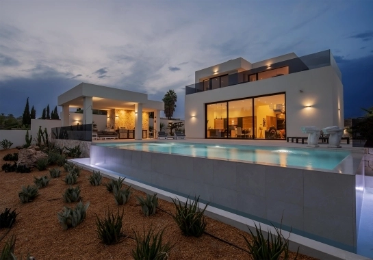 Vista de vivienda, módulo de barbacoa y piscina iluminados